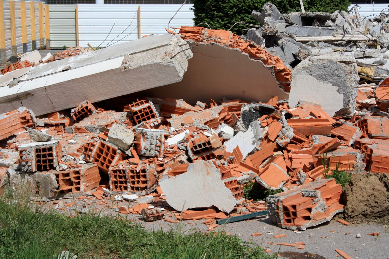 Montón de escombro de demolición con ladrillo hueco roto, losas de hormigón y restos de yeso mezclados